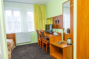 brązowe biurko z dwoma krzesłami i telewizorem