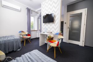 pokój z telewizorem, kolorowe krzesła, drzwi