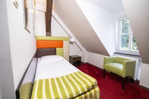 pokój z łóżkiem jednoosobowym, zielony fotel