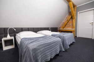 dwa łóżka pojedyncze, białe drzwi