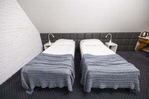 dwa łóżka pojedyncze ze stolikami nocnymi