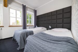 dwa łóżka pojedyncze, widok zza okien