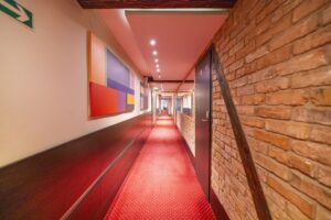 korytarz, obrazy na ścianach, drzwi do pokoi hotelowych