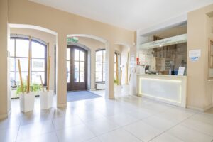 duże drzwi wejściowe, z prawej strony recepcja hotelu